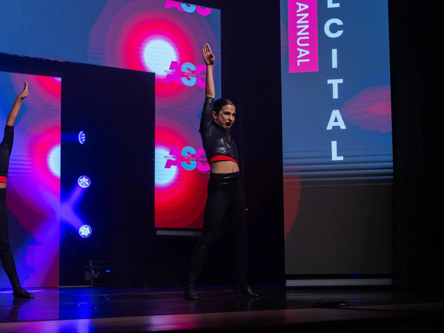 A soloist salutes the house beneath the Annual Recital title panel